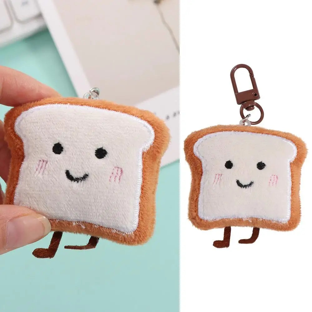 A soft, fluffy toast bread plush charm with a brown crust and white interior, attached to a metal keyring.