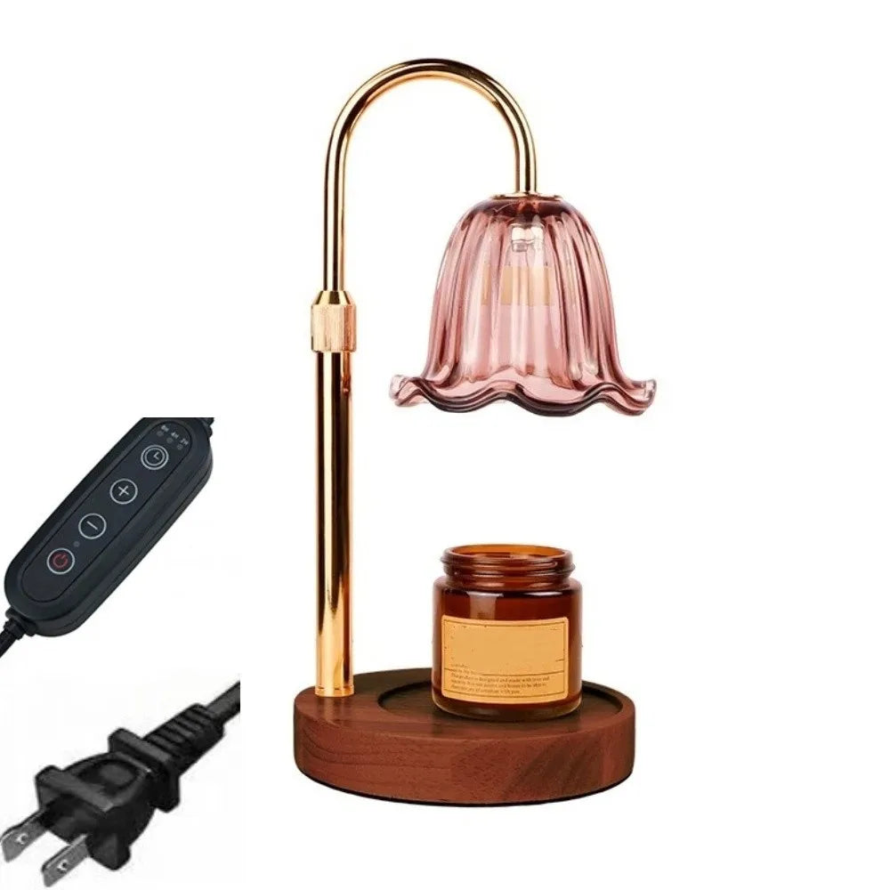 A gold-toned adjustable height aromatherapy candle warmer lamp with a pink glass shade and a black remote control.