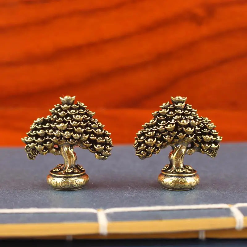 Brass fortune tree ornament with ingot accents displayed on a dark surface.