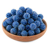 A pile of deep blue textured resin beads for jewelry making in a wooden bowl.