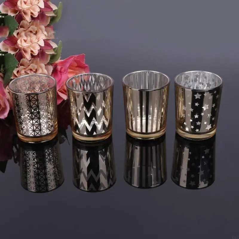 Four silver glass votive candle holders with patterned textures and reflective bases.