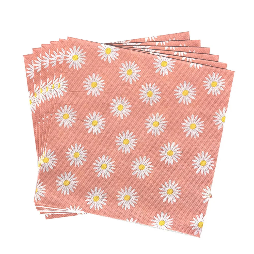 A stack of disposable pink napkins featuring a white daisy flower pattern.