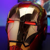 A close-up of a metallic red and gold Iron Man helmet with glowing red eye slits, displayed on a dark surface.