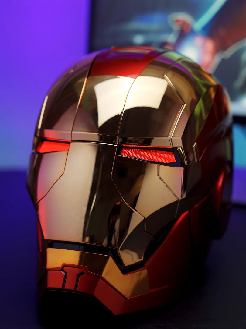 A close-up of a metallic red and gold Iron Man helmet with glowing red eye slits, displayed on a dark surface.