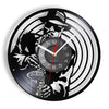 A black wall clock face featuring a stylized silhouette of a person and a vinyl record design.