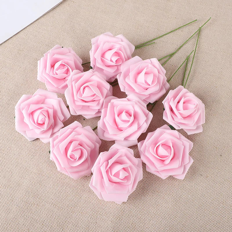 A cluster of twenty pink foam rose blooms on a beige fabric background.