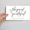 A white card with handwritten script saying beyond grateful and thank you so much