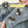 A close-up of a black butterfly waist clincher being attached to denim fabric.
