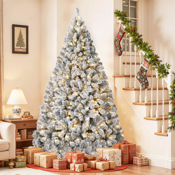 A flocked artificial Christmas tree decorated with warm white LED lights standing in a bright room.