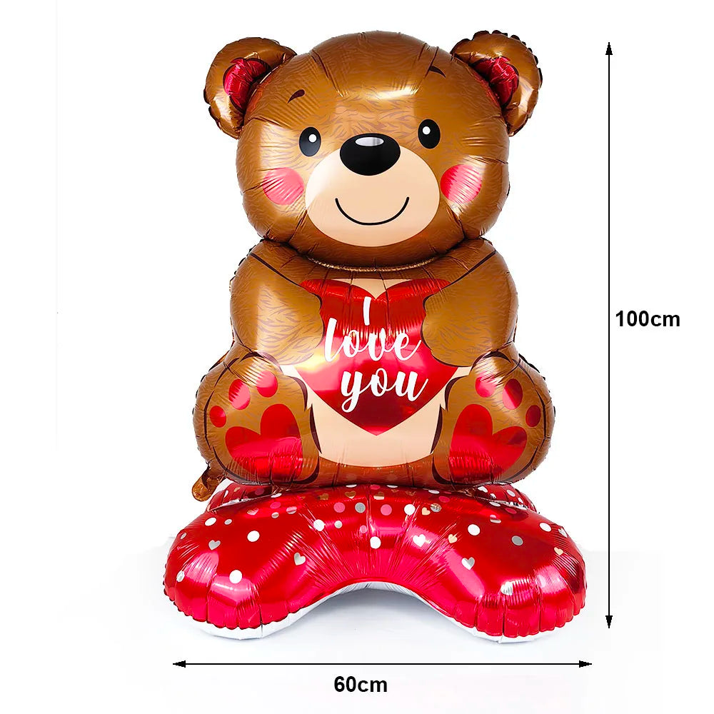 A large brown teddy bear balloon with a red heart design and a red foil finish.