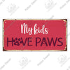 Rustic wooden wall plaque sign with white text reading My kids HAVE PAWS on a red background