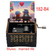 A wooden music box with a hand crank, featuring two figures and the title Music: married life.