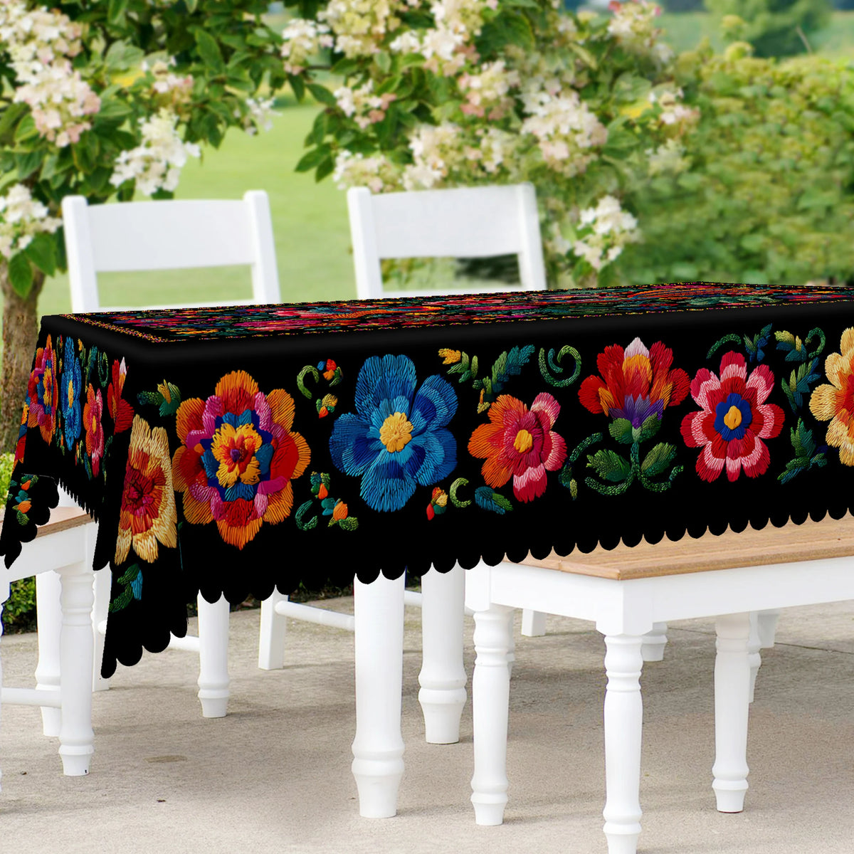 Vibrant Mexican style embroidered tablecloth displayed on a white wooden table outdoors.