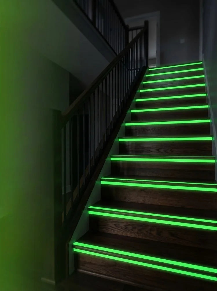 Escalier en bois foncé avec des bandes LED vertes illuminant les marches et la balustrade.
