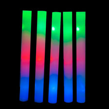 A vertical arrangement of glowing foam sticks in a rainbow gradient of green, red, and blue.