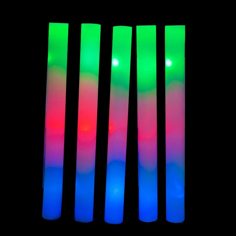 A vertical arrangement of glowing foam sticks in a rainbow gradient of green, red, and blue.