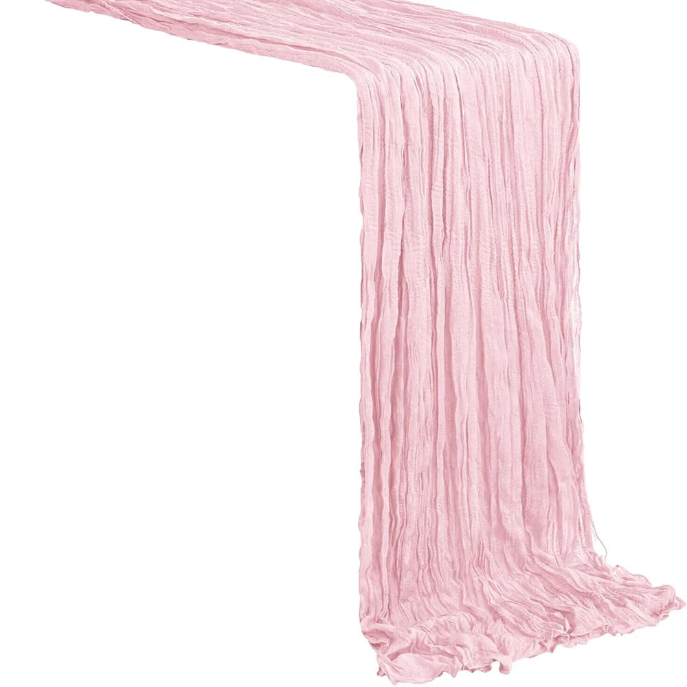 A rustic pink semi-sheer gauze table runner draped diagonally.
