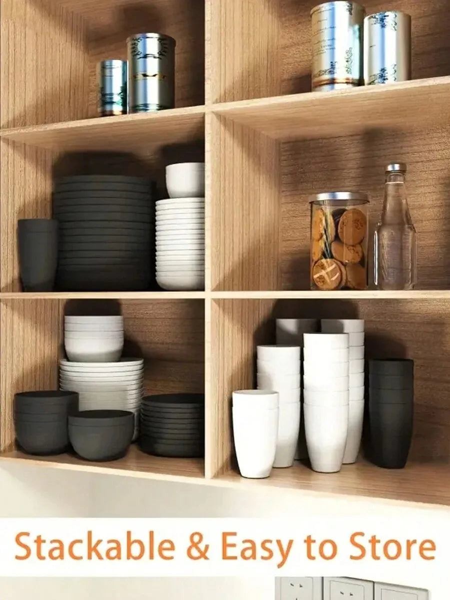 A set of stackable reusable plastic tableware in various shades of gray and white stored on wooden shelves.