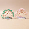 A pair of natural crystal trees, one green and one pink, mounted on agate bases for home decor.
