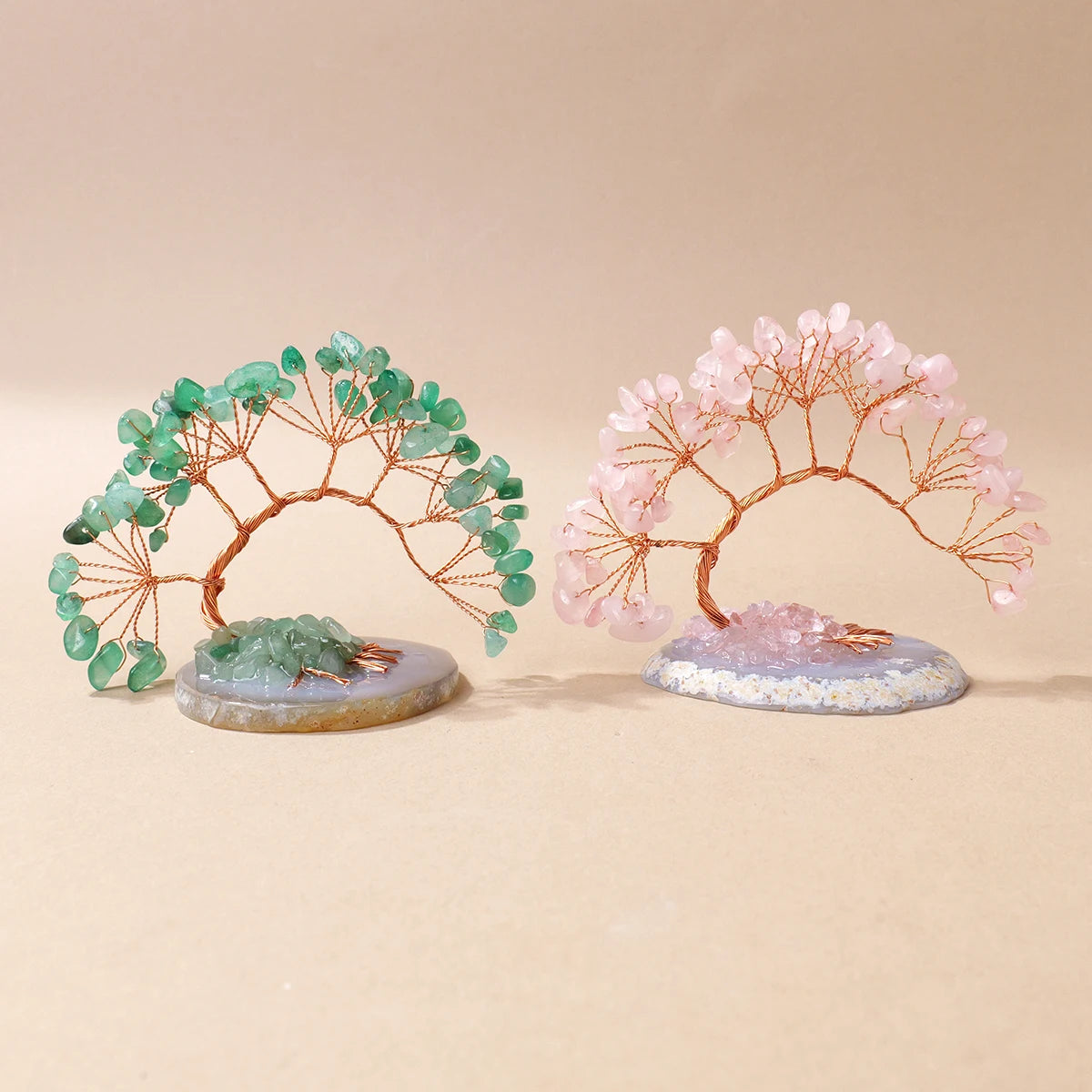 A pair of natural crystal trees, one green and one pink, mounted on agate bases for home decor.