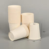 A stack of beige disposable paper cups, including a single cup, are shown against a gray background.