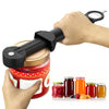A hand is using a black ergonomic jar and bottle opener set to open a red glass jar.