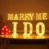 Glowing LED letter lights spelling out MARRY ME I DO on a shelf for wedding or party decor