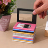 A stack of retro magnetic photo frames in various pastel colors is being held by a hand.