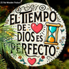 A white wooden plaque with a black inspirational quote in Spanish, surrounded by decorative elements and greenery.