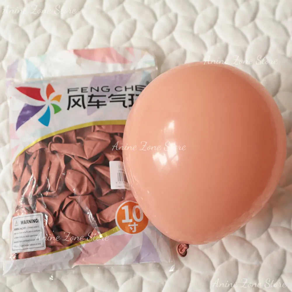 A large, round pastel pink latex balloon is shown next to its packaging.