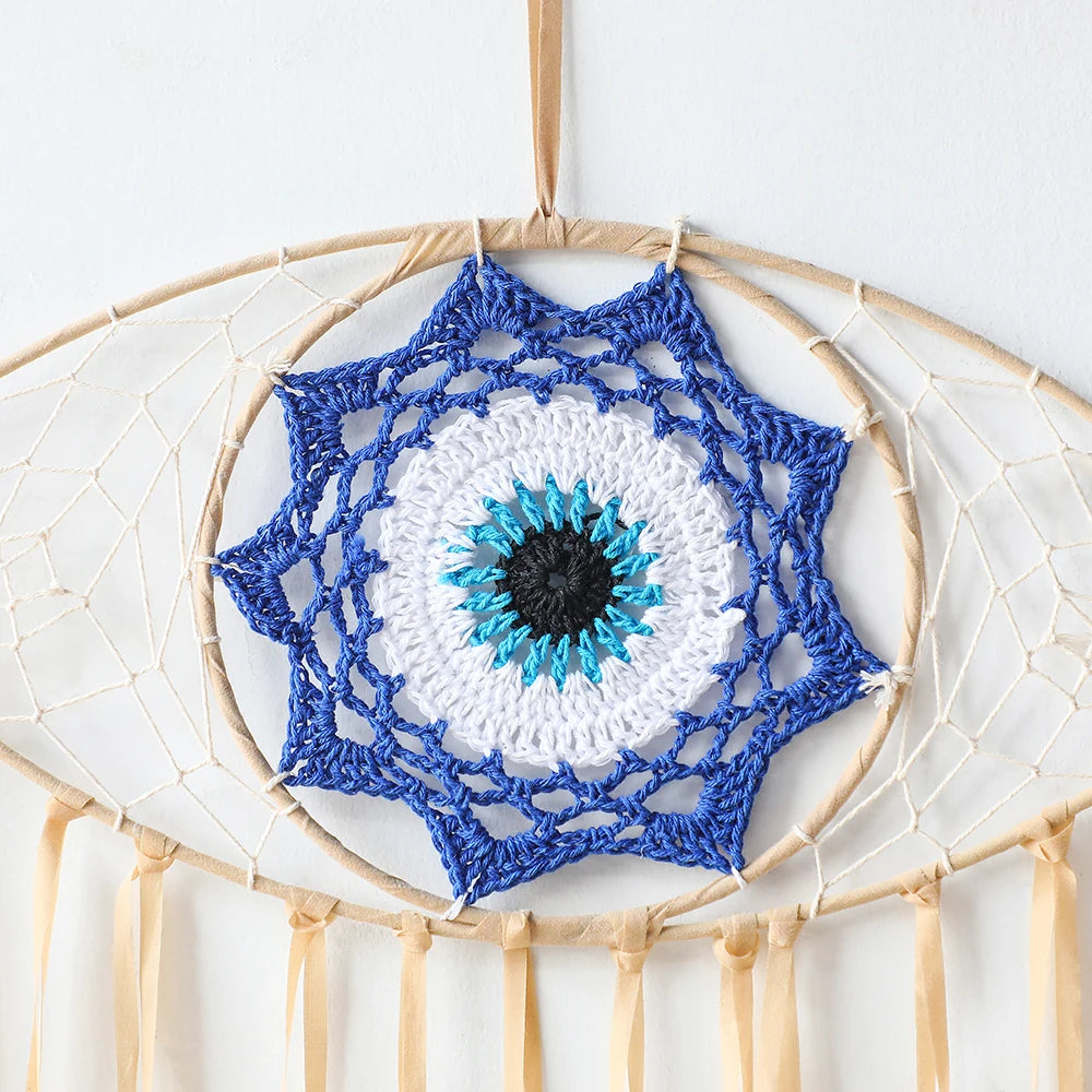 Handmade boho evil eye dream catcher wall decor featuring a blue and white eye design with hanging threads