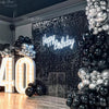 Fond mural de sequins brillants foncés avec texte 'Joyeux anniversaire' et ballons argent et noir.