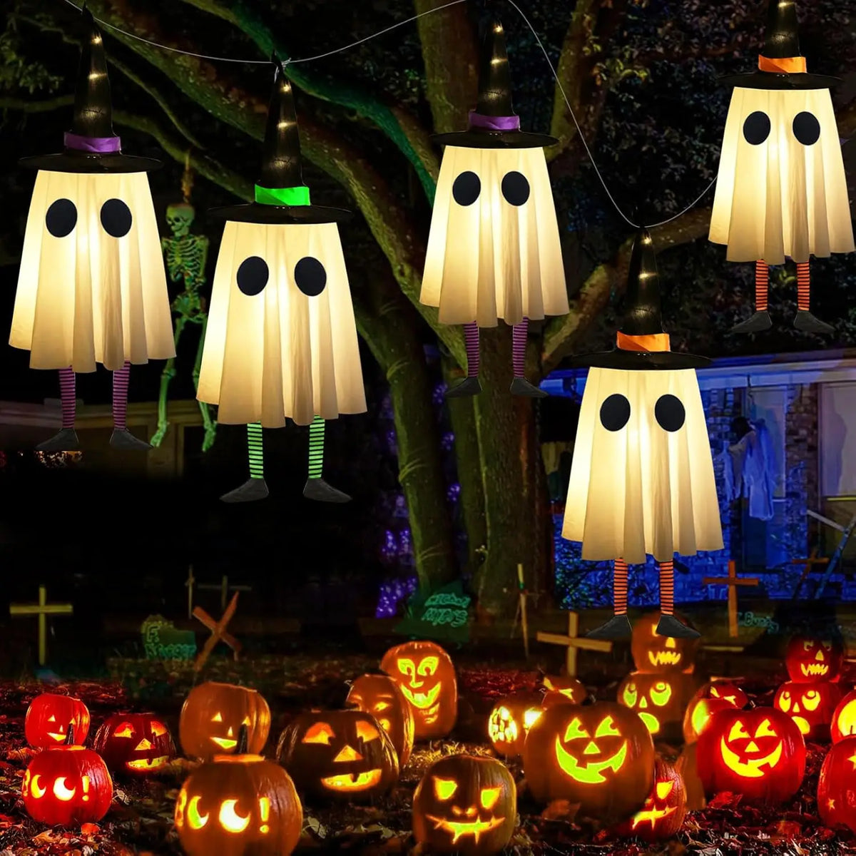 Halloween hanging ghost lights with witch hats illuminating a dark outdoor scene.