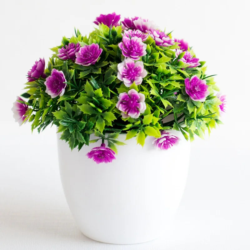 Un arrangement vibrant de fleurs de bonsaï artificielles violettes et roses, dans un vase en céramique blanche.