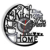 A black wall clock with a design featuring text and heart motifs, showing the time.