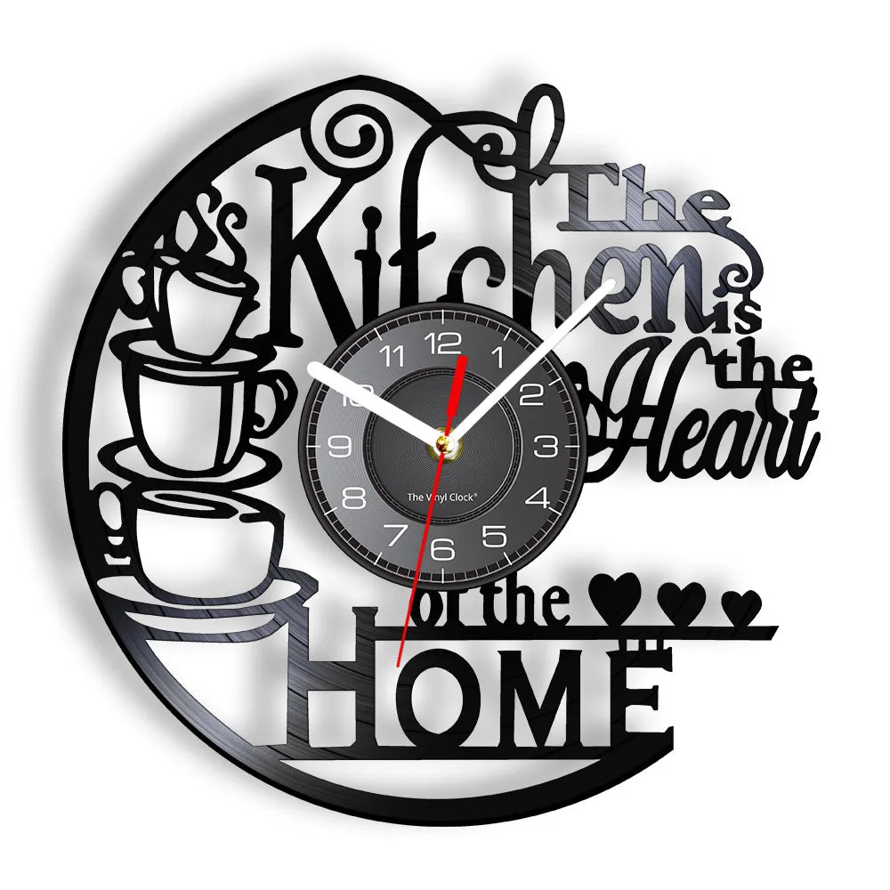 A black wall clock with a design featuring text and heart motifs, showing the time.