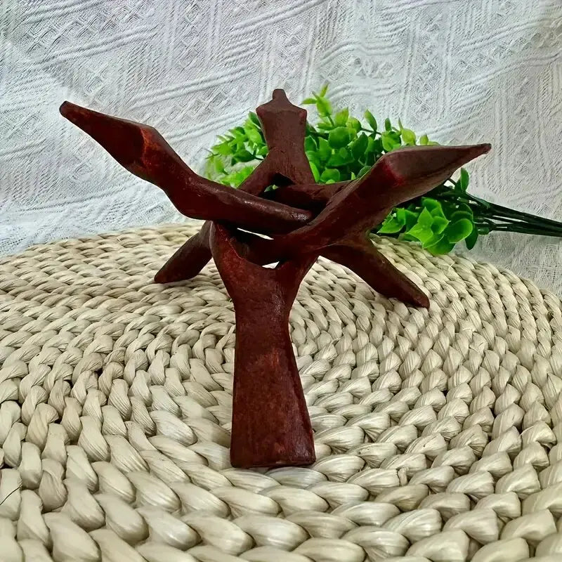 A dark reddish-brown wooden tripod stand for displaying an abalone shell or crystal ball.