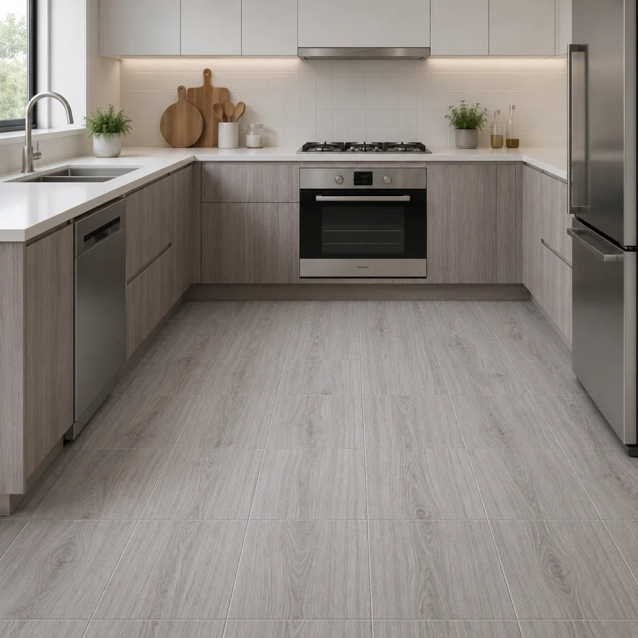 Modern kitchen featuring light wood grain flooring and gray cabinetry with a stainless steel backsplash.