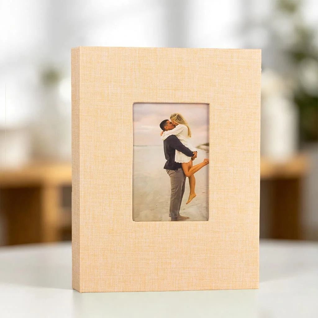 A light wood framed photo album with a display window showing a couple embracing outdoors.