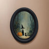 Oval wall art featuring a witch silhouette and a black cat in a misty woodland scene.