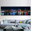 A canvas print depicting the New York City skyline at night with city lights reflecting on water.