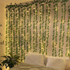 Artificial leaf string lights draped across a wall creating a lush green vertical display for home decor