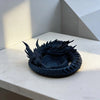 A dark, dragon-themed desktop storage tray organizer resting on a white surface.