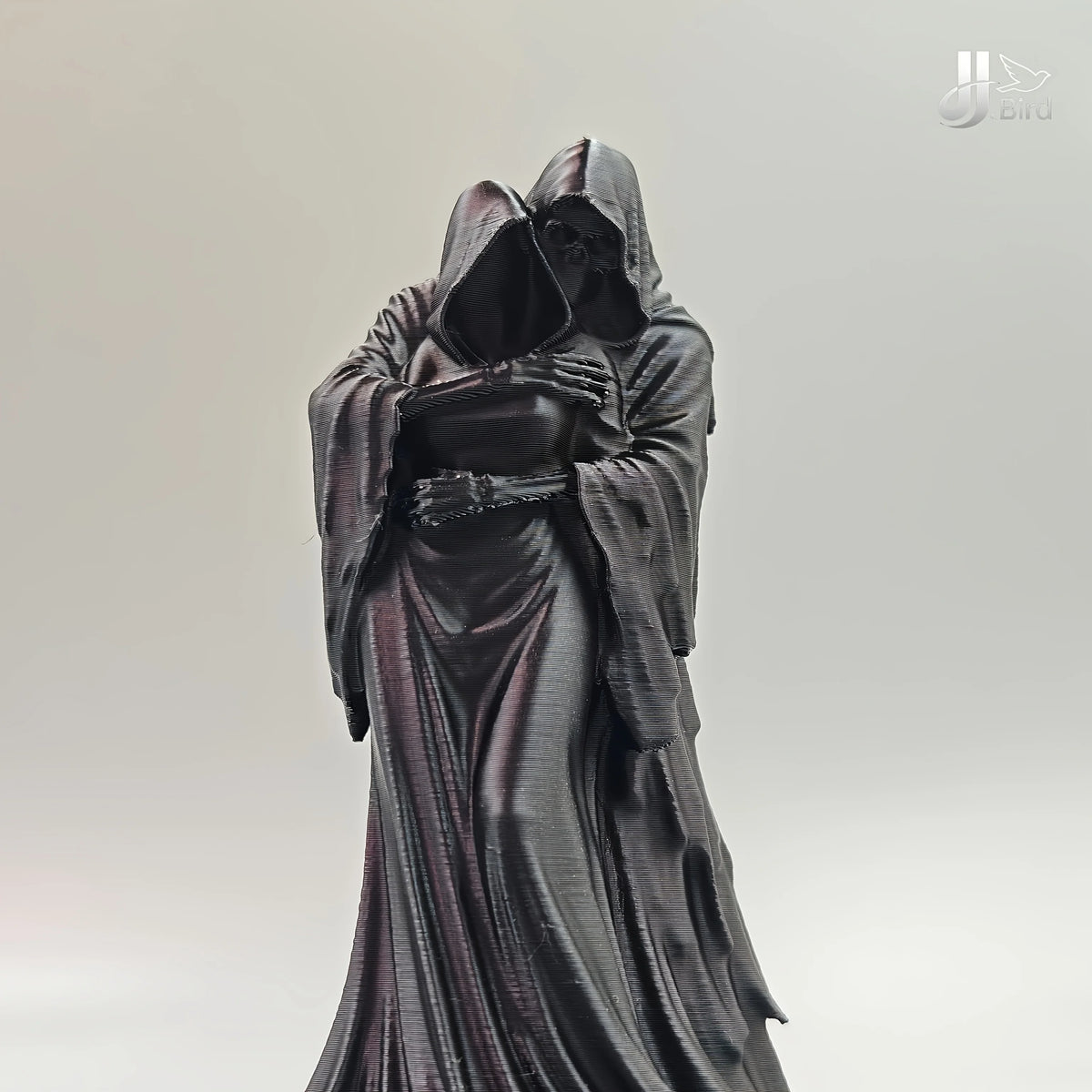 A dark, flowing hooded figure collectible figurine in a draped gown.