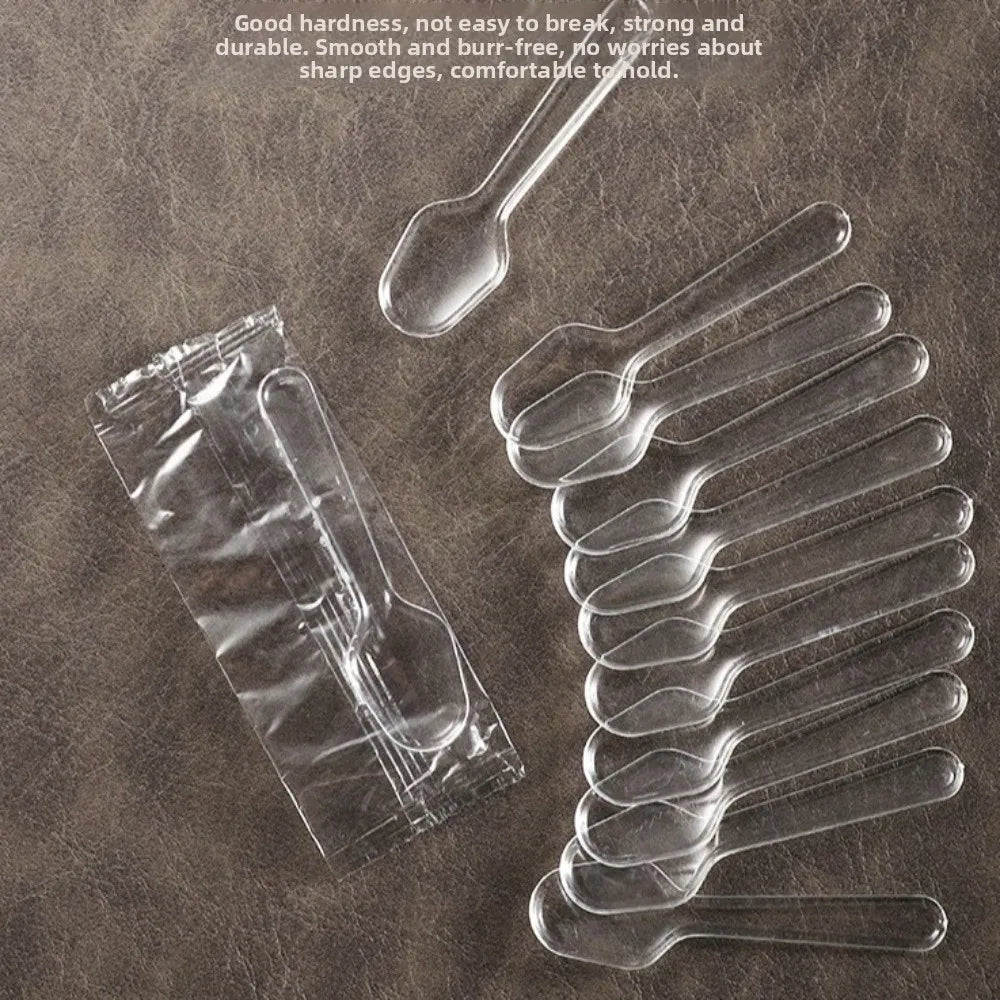 Clear plastic disposable spoons arranged on a brown surface with descriptive text.