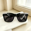 Black sunglasses decorated with wooden letters spelling just married
