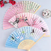 Three folding silk hand fans in pink, green, and blue featuring floral and bird designs.