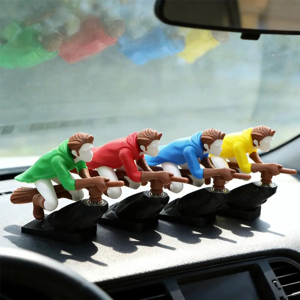 A set of witch and wizard flying carriage dashboard drift decor figurines in various colors are displayed on a car dashboard.