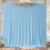 Light blue pleated fabric backdrop curtains decorated with a floral arrangement