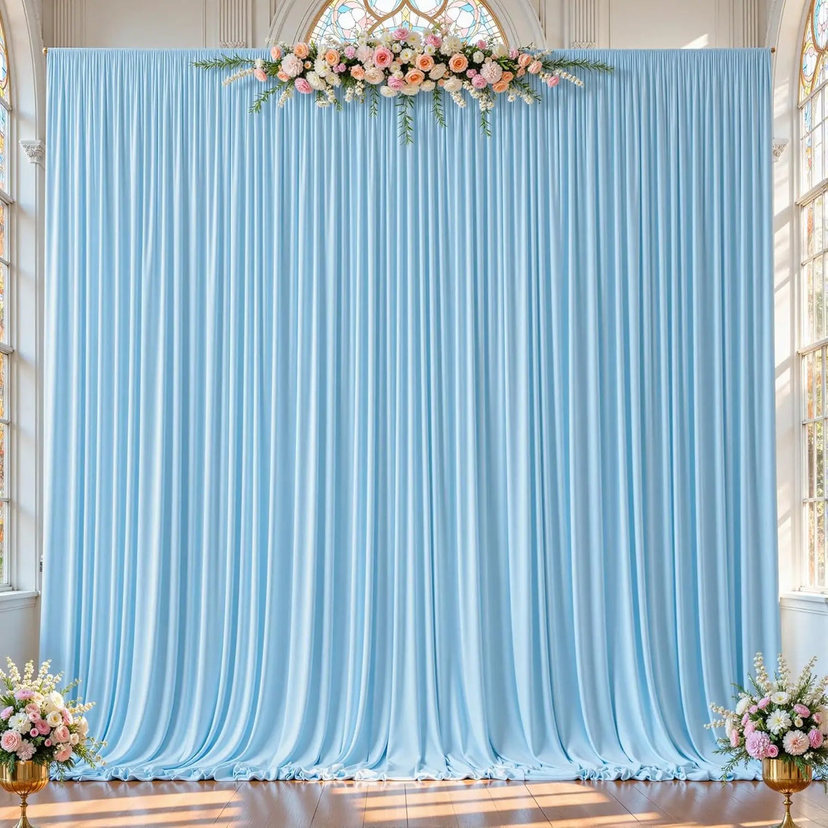 Light blue pleated fabric backdrop curtains decorated with a floral arrangement